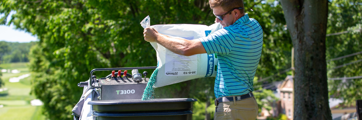 Pouring POLYON fertilizer into a spreader